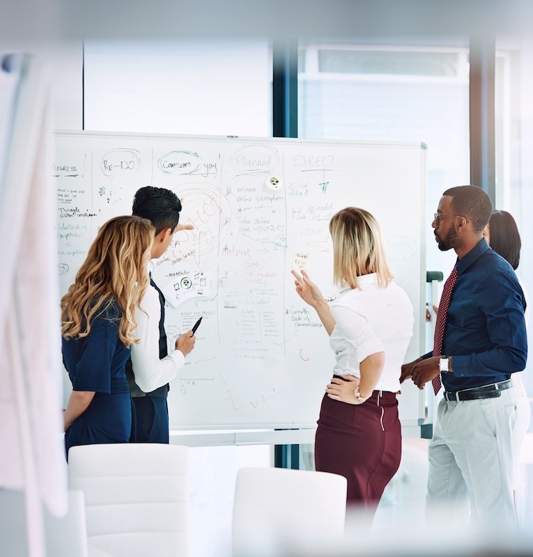 Business professionals meeting around a whiteboard